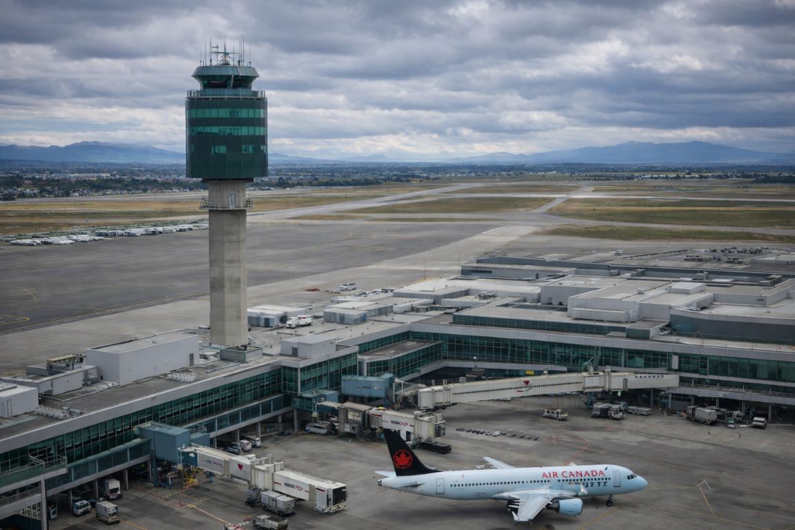 YVR Vancouver International Airport terminal and control tower with airplane boarding during a Vancouver Canada Tours excursion